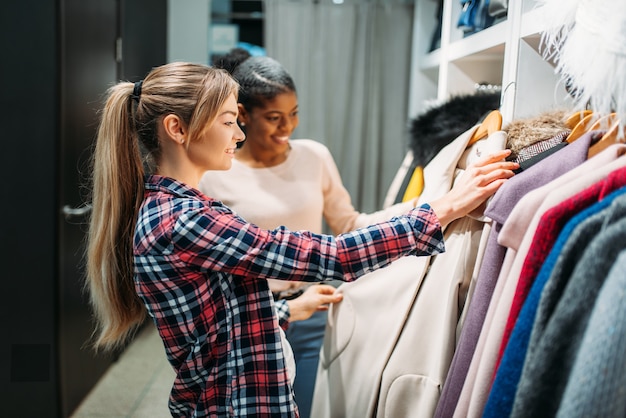 Duas namoradas escolhendo roupas na loja