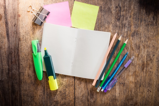 Duas notas auto-adesivas coloridas em branco, caderno, lápis, caneta de marca-texto, clip