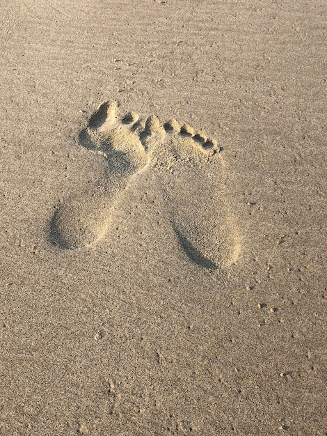 Duas pegadas no fundo da praia de areia