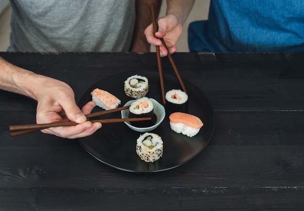 Duas pessoas comendo sushi.