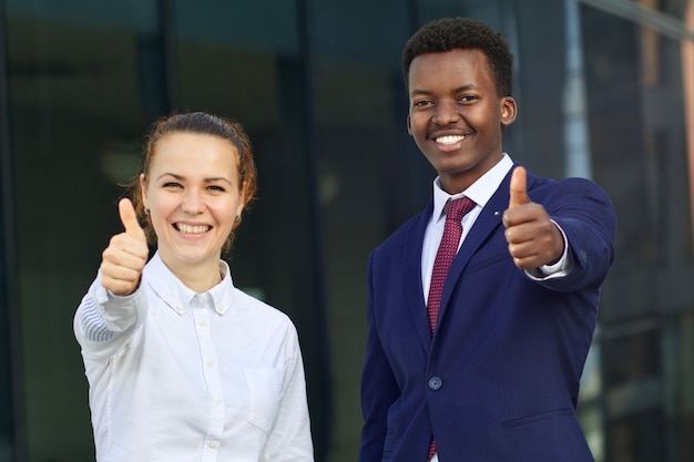 Duas pessoas felizes e sorridentes, empresário e empresária mostrando o polegar como um gesto