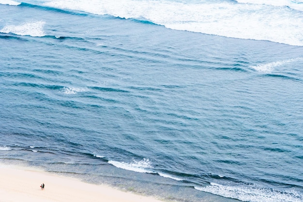 Duas pessoas no oceano de praia de areia