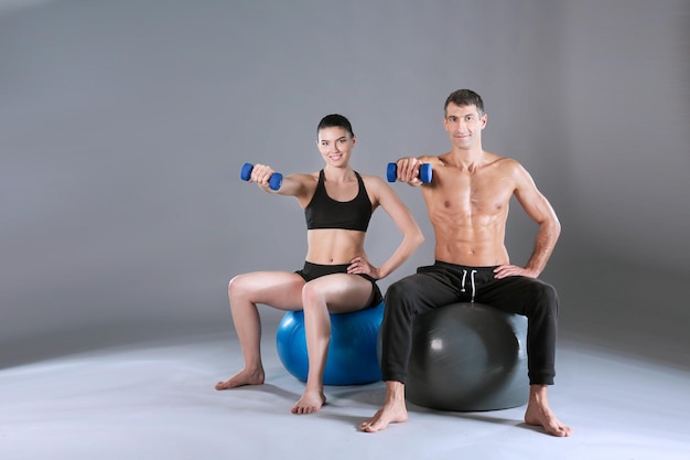 Duas pessoas sorridentes com bola de fitness no ginásio Instrutor de fitness pessoal Treino pessoal Treino de ginásio