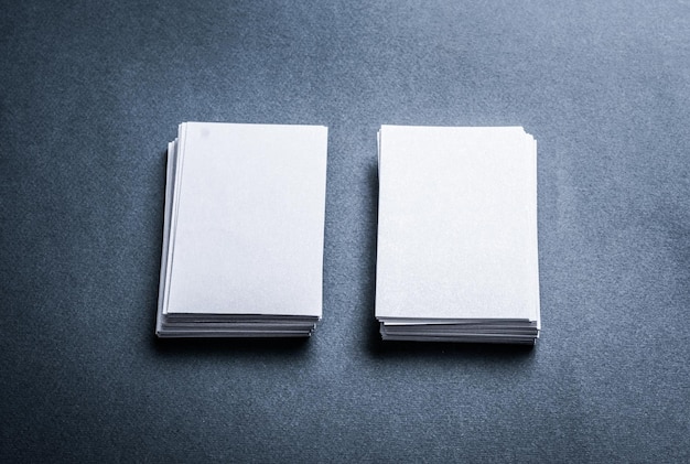 Duas pilhas de cartões de visita de papel em branco no plano de fundo texturizado