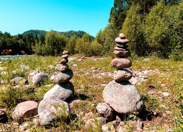 Duas pirâmides feitas de pedras nas margens de um rio de montanha. lugar de poder de altai