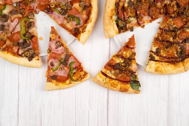 Duas pizzas grandes deliciosas diferentes em um fundo claro de madeira