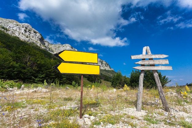 Duas placas de sinalização na encruzilhada na montanha e na floresta