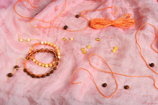 Duas pulseiras shamballa artesanais feitas de rudraksha e contas de âmbar em um tecido rosa