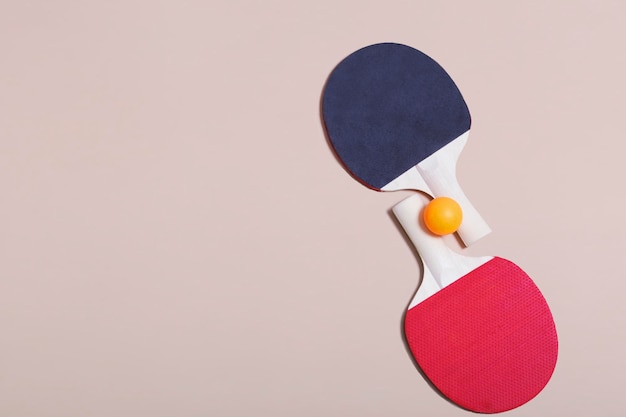 Duas raquetes de tênis e bolas laranja e brancas sobre um fundo bege. Recreação esportiva. Raquetes de ping pong