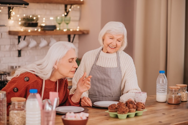 Duas senhoras de cabelos grisalhos cozinhando na cozinha moderna