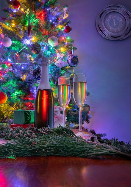 Duas taças de champanhe espumante na noite de véspera de ano novo com relógio marcando dois minutos antes da meia-noite. decoração de natal .