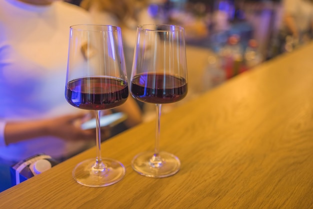 Duas taças de vinho em um bar com linda luz ambiente.