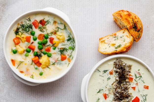 duas tigelas brancas com sopa de vegetais no pão