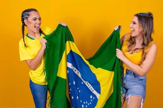 Duas torcedoras do Brasil comemorando em fundo amarelo