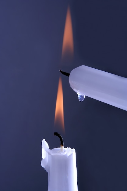 Duas velas brancas acesas em um azul