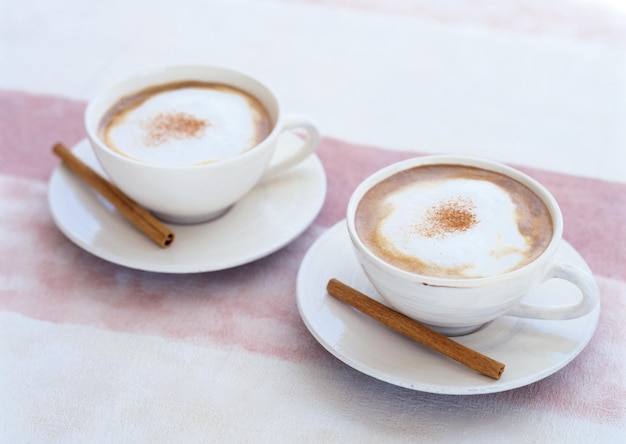 Duas xícaras de café com canela no topo