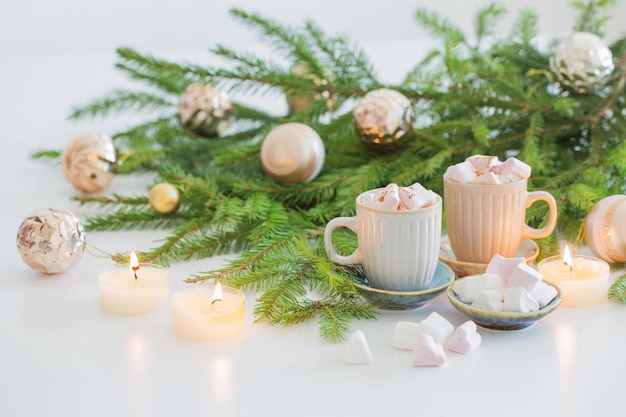 Duas xícaras de café com marshmallow e ramos de abeto de natal