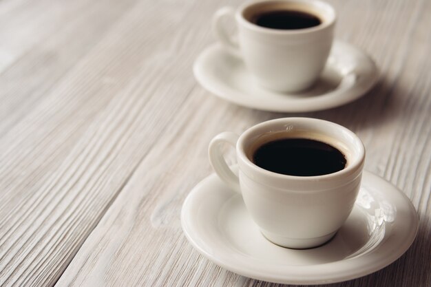 Duas xícaras de café em uma mesa de madeira branca