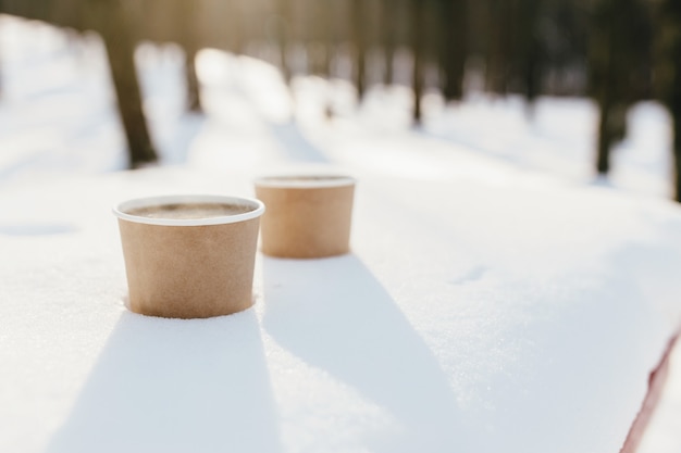 Duas xícaras de café na neve na floresta