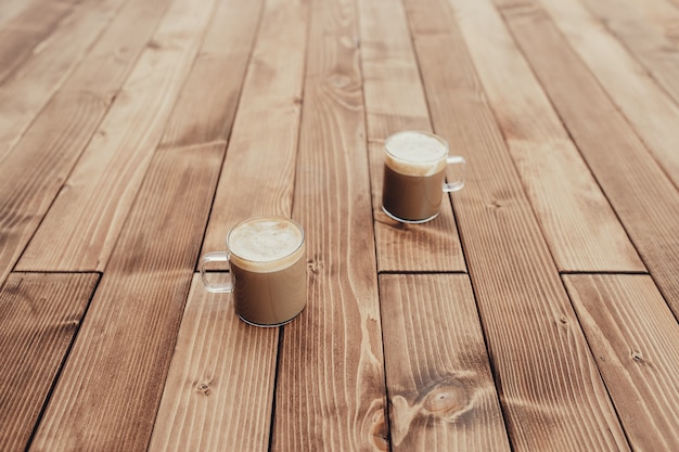 Duas xícaras de café no fundo do terraço de madeira marrom. Foto de alta qualidade