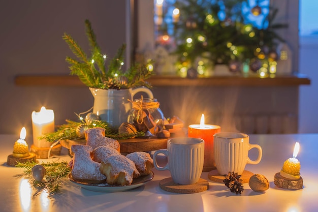 Duas xícaras de chá com assados caseiros de Natal na cozinha com decoração de Natal