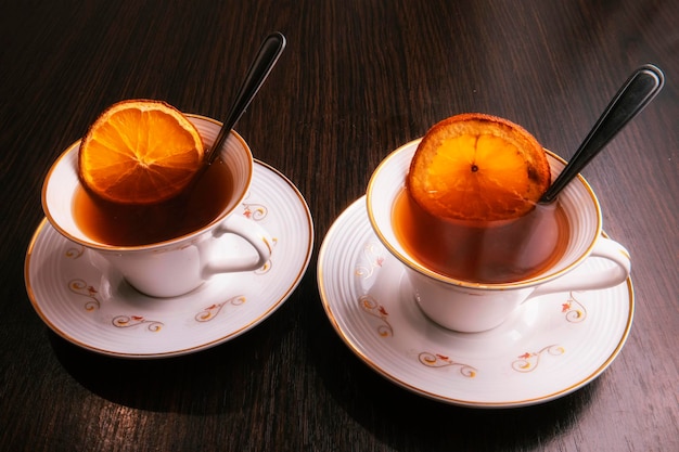 Duas xícaras de chá com laranjas secas