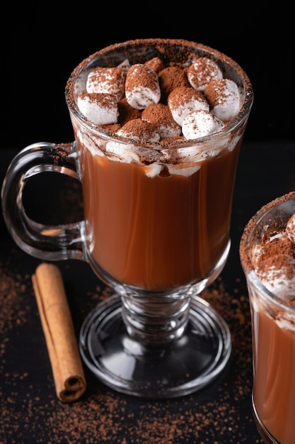 Duas xícaras de chocolate quente ou bebida quente com marshmallow em fundo escuro