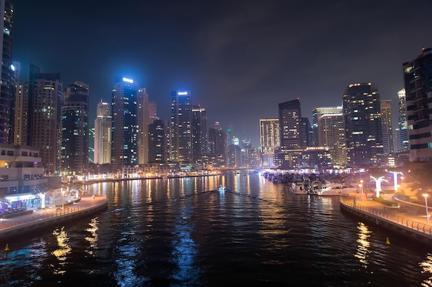 Dubai, Emirados Árabes Unidos - 26 de dezembro de 2017: canal de água no horizonte de Dubai Marina à noite. Torres residenciais com iluminação. Arquitetura ou estrutura e design. Férias e desejo de viajar.