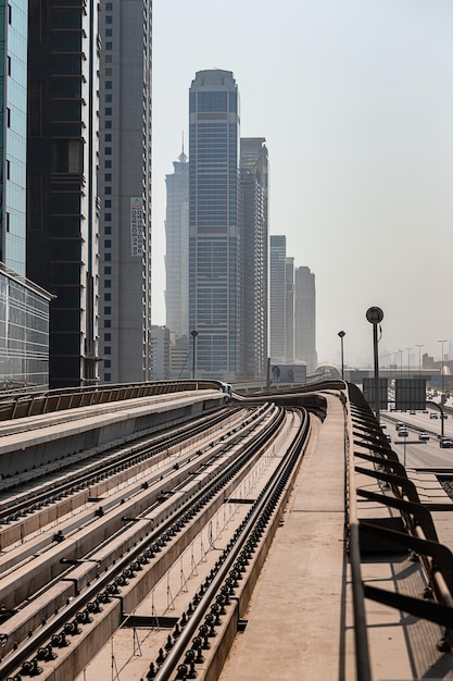 Dubái Emiratos Árabes Unidos 08 de noviembre de 2021 Metro de Dubái sobre raíles al fondo de los rascacielos Famosa línea roja del metro al aire libre