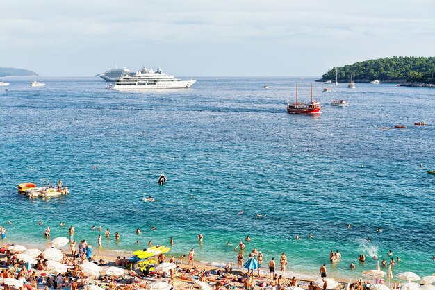 Dubrovnik, Croácia - 18 de agosto de 2016: Pessoas na praia de Banje, no mar Adriático, em Dubrovnik, Croácia.