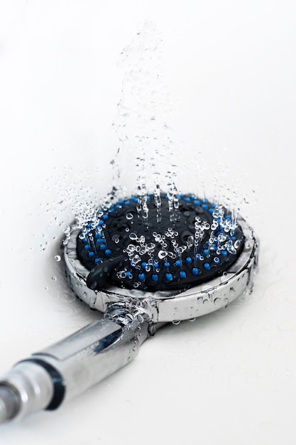 Ducha de baño de aluminio con gotas de agua.