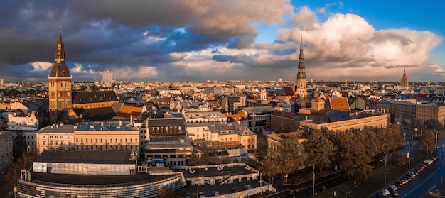 Ducha de lluvia sobre Riga, Letonia al atardecer. Vista aérea del casco antiguo de Riga al atardecer con nubes tormentosas y lluvia ligera en la luz del sol. Tormenta mágica sobre la ciudad. Letonia hermosa.