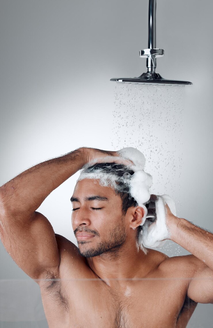 Foto duche e shampoo masculino no estúdio para lavar o cabelo água e limpeza ou cuidado em fundo branco cosméticos e espuma para a pessoa masculina para tratamento na rotina matinal de cuidados com o cabelo e higiene ou beleza