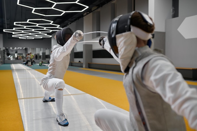 Duelo de tiradores durante el combate de esgrima. Lección de entrenamiento de dos espadachines en el concepto de clase de arte marcial. Compañeros de combate peleando con estoques