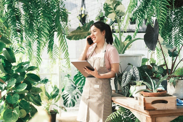 La dueña de una tienda de plantas joven está revisando el pedido del cliente desde el sitio web