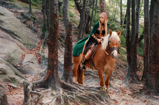 Foto duende feminino na floresta com seu cavalo