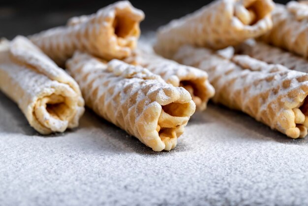 Dünne knusprige Waffeln liegen auf einem schwarzen Tisch