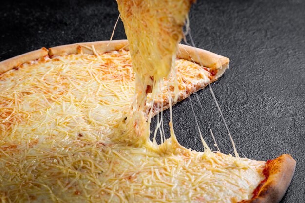 Dünne Kruste Pizza dunkler Hintergrund Hand zieht ein Stück Pizza