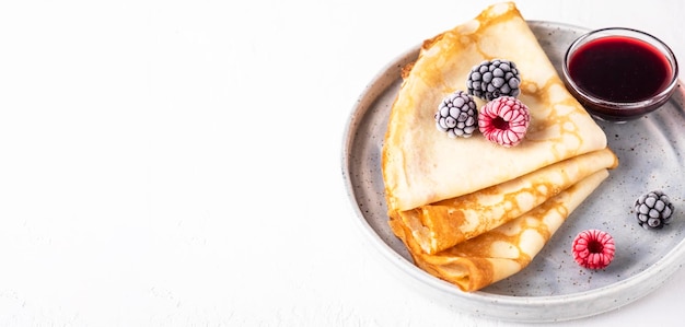 Dünne Pfannkuchen mit Beeren auf einem Teller Platz kopieren