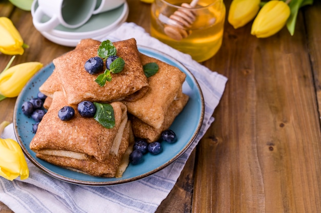 Dünne Pfannkuchen mit Quark und Erdbeeren. Gesundes traditionelles Frühstückskonzept. Backen für einen traditionellen russischen Karneval im Frühjahr, Maslenitsa. Speicherplatz kopieren.