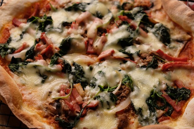 Foto dünnkruste italienische pizza auf einem holztisch mit mozzarella-käse-salami-pepperoni