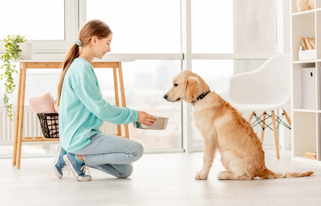 Dueño alegre que alimenta el perro lindo