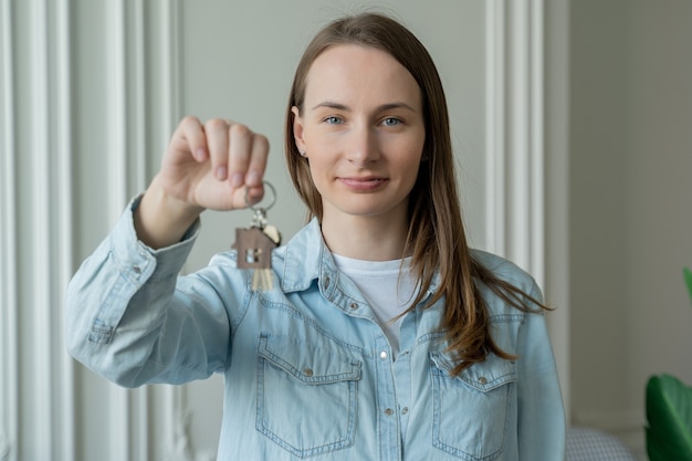 Dueño de apartamento mujer feliz con llaves. Retrato de mujer feliz moviéndose mostrando las llaves del nuevo apartamento