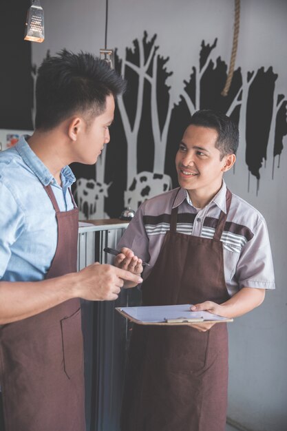 Foto dueño de cafetería discutiendo con su empleado