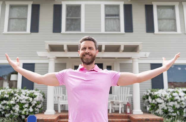 Dueño de hombre barbudo feliz cerca de casa nueva después de alquilar o comprar casa nueva, propiedad.