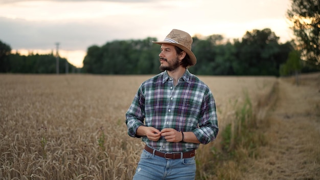 El dueño del negocio de un joven agricultor mira la cámara en el campo