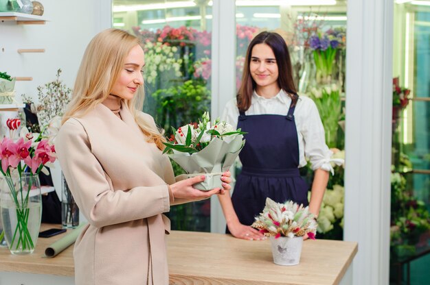 El dueño de la tienda de flores vende un ramo de rosas blancas a un comprador