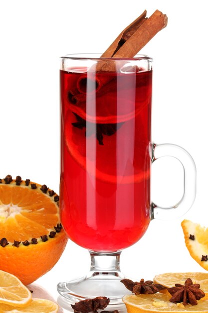 Duftender Glühwein im Glas mit Gewürzen und Orangen isoliert auf weiß