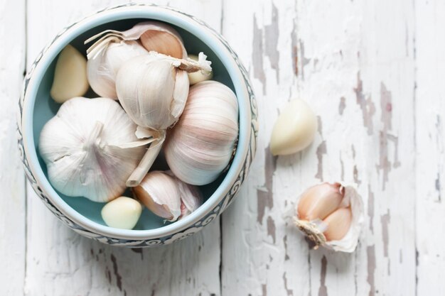 Duftender Knoblauch in einer kleinen Schüssel auf einem alten Holzgrund