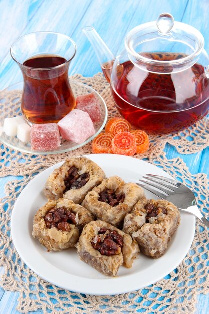 Dulce baklava en un plato con té en la mesa